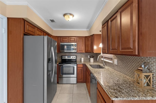 kitchen with visible vents, light tile patterned floors, brown cabinetry, stainless steel appliances, and a sink