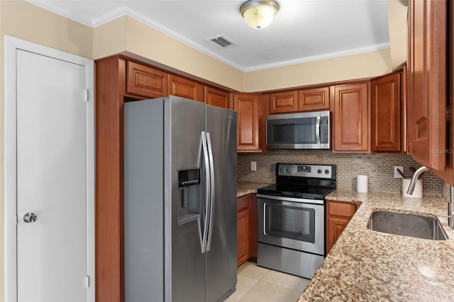 kitchen with visible vents, backsplash, brown cabinets, stainless steel appliances, and a sink