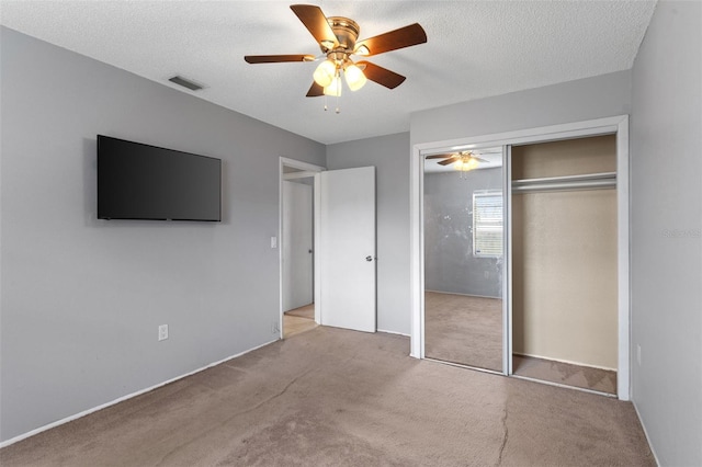 unfurnished bedroom with visible vents, ceiling fan, a closet, a textured ceiling, and carpet flooring