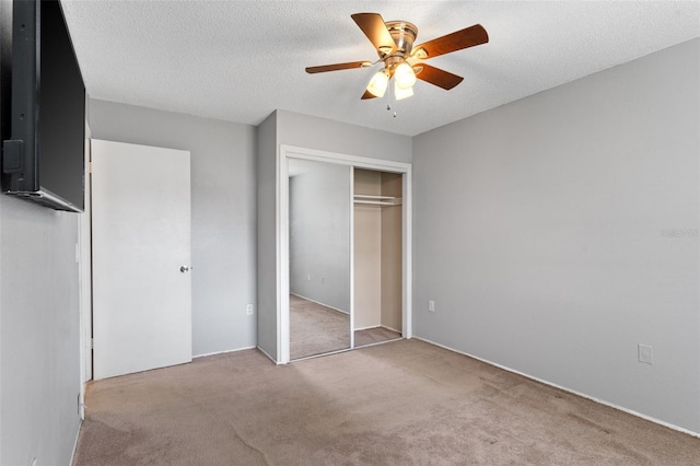 unfurnished bedroom featuring a closet, carpet floors, a textured ceiling, and ceiling fan