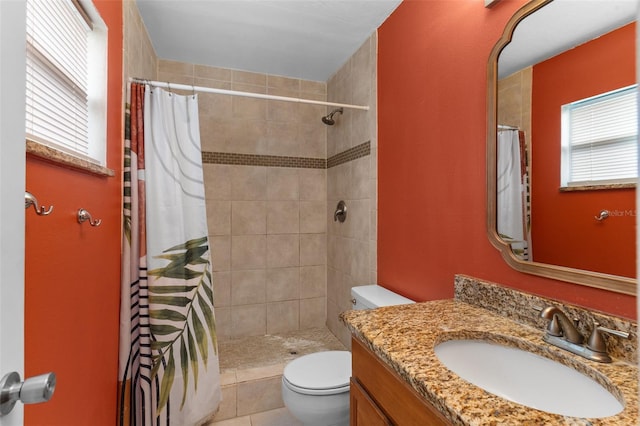 full bath featuring vanity, toilet, a wealth of natural light, and tiled shower