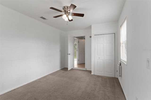 unfurnished bedroom featuring carpet flooring, visible vents, a closet, and ceiling fan