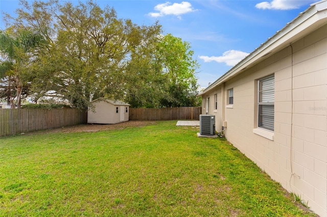 view of yard featuring a storage shed, an outbuilding, cooling unit, and a fenced backyard