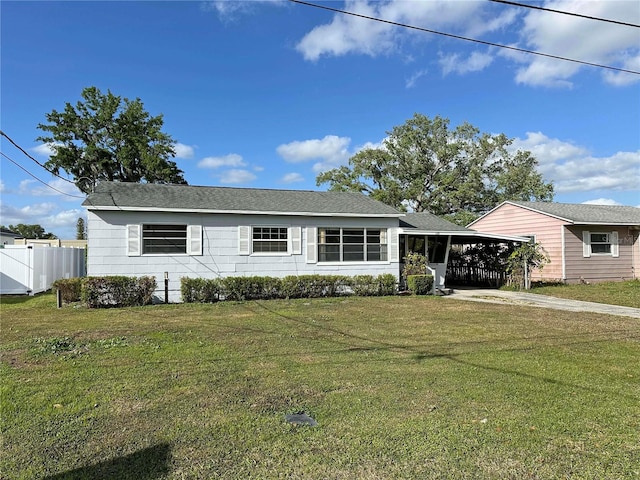 single story home featuring an attached carport, driveway, a front yard, and fence