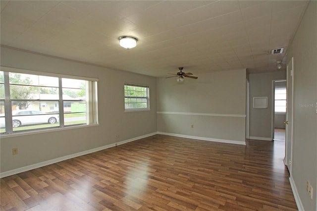 empty room with visible vents, baseboards, and dark wood-type flooring