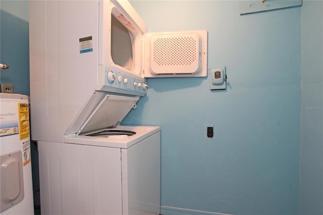 laundry area featuring laundry area, water heater, and stacked washing maching and dryer