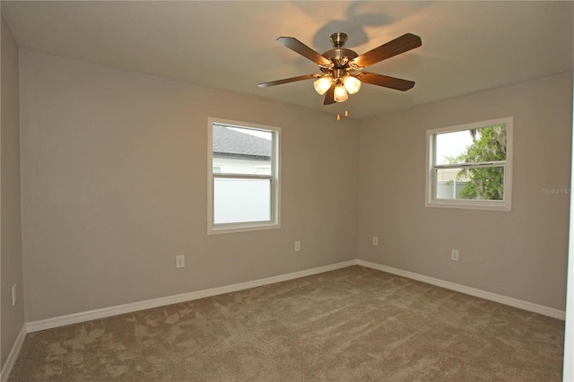 carpeted empty room with baseboards and ceiling fan