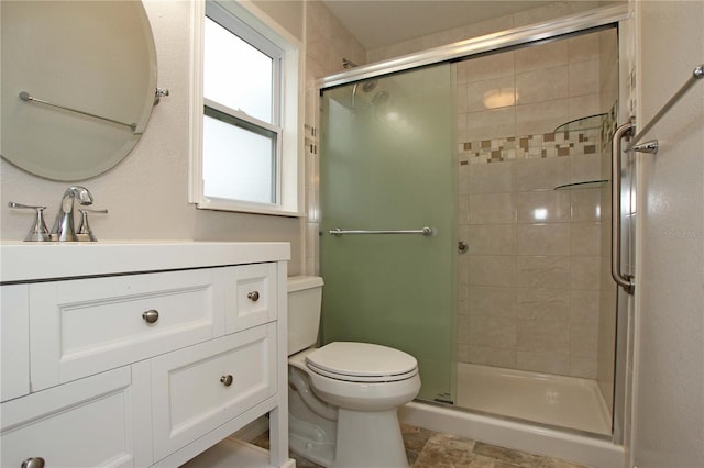 full bathroom featuring vanity, a shower stall, and toilet