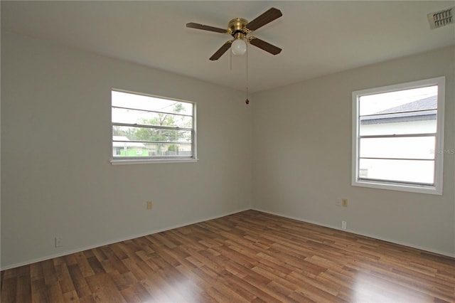 unfurnished room featuring ceiling fan, visible vents, and wood finished floors