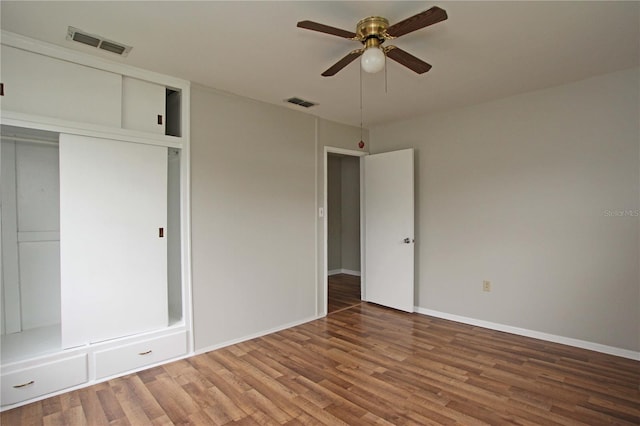 unfurnished bedroom featuring a closet, visible vents, and wood finished floors