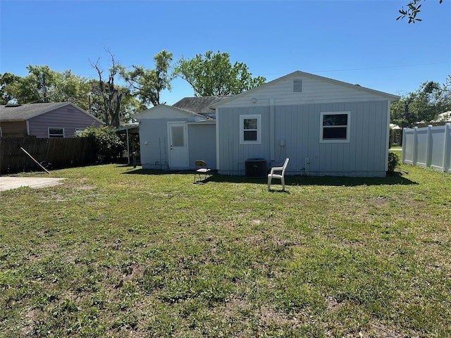 rear view of property with a lawn and fence