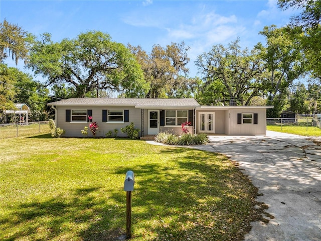 single story home with a carport, a front yard, driveway, and fence