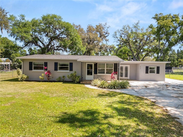 single story home featuring french doors, an attached carport, concrete driveway, and a front yard