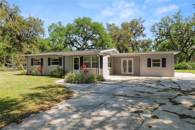 ranch-style home featuring a carport, french doors, a front lawn, and driveway