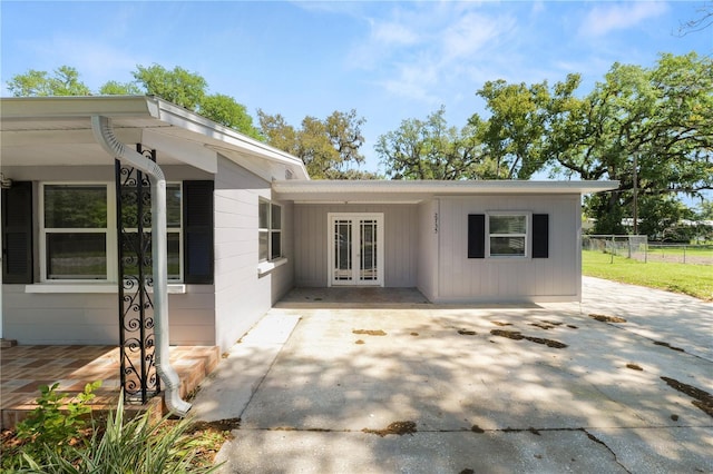 rear view of house featuring a patio area, french doors, and fence