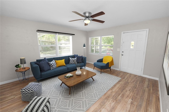 living room with baseboards, wood finished floors, and a ceiling fan