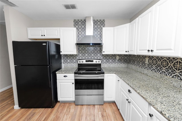 kitchen with visible vents, stainless steel electric stove, freestanding refrigerator, white cabinets, and wall chimney range hood