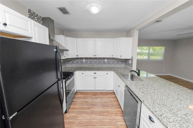 kitchen with visible vents, freestanding refrigerator, range with electric cooktop, dishwasher, and wall chimney range hood