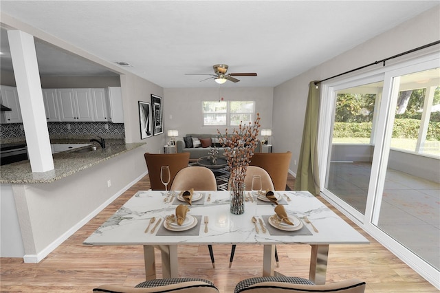 dining room featuring light wood-type flooring, visible vents, a healthy amount of sunlight, and ceiling fan