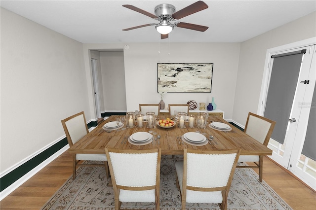 dining space with ceiling fan, baseboards, and light wood-style flooring