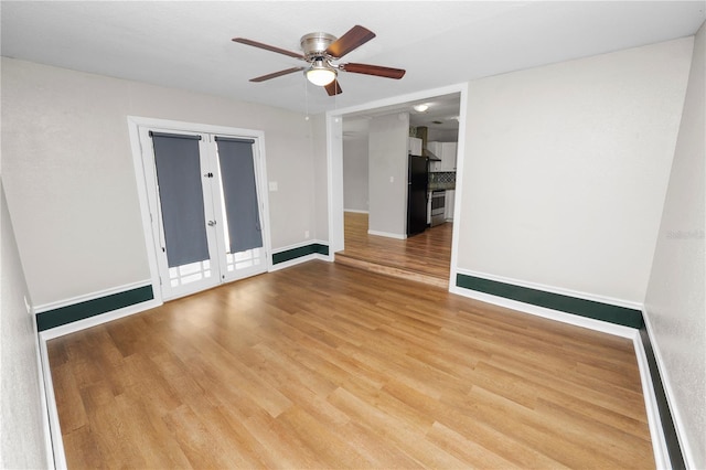 unfurnished room featuring baseboards, wood finished floors, and ceiling fan