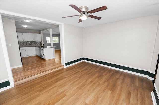 unfurnished living room with baseboards, ceiling fan, and wood finished floors