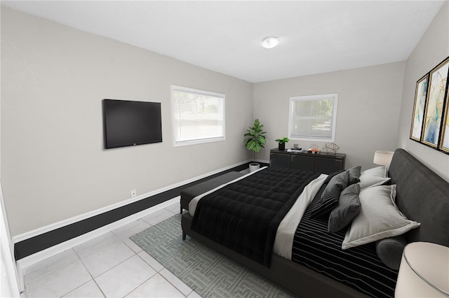 bedroom with light tile patterned flooring and baseboards