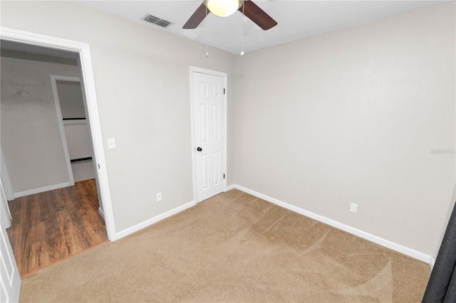 unfurnished bedroom with a ceiling fan, baseboards, visible vents, and carpet floors