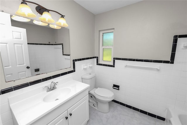 bathroom featuring toilet, wainscoting, a bathtub, walk in shower, and vanity