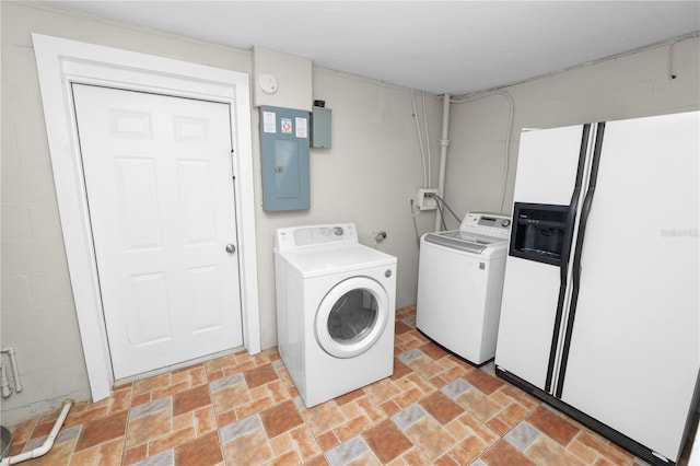 laundry area with electric panel, stone finish flooring, separate washer and dryer, and concrete block wall