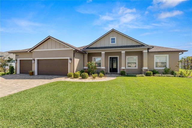 view of front of home featuring decorative driveway, a front lawn, an attached garage, and stucco siding