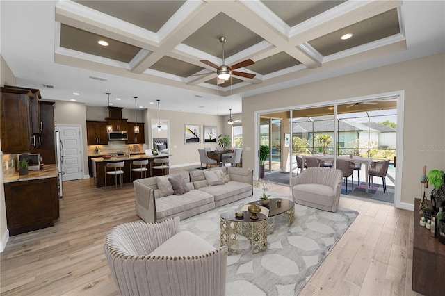 living room featuring a ceiling fan, baseboards, and coffered ceiling