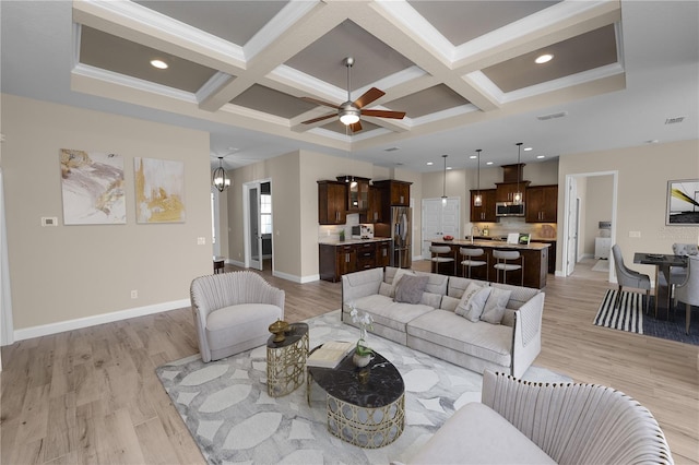 living room with coffered ceiling and light wood finished floors