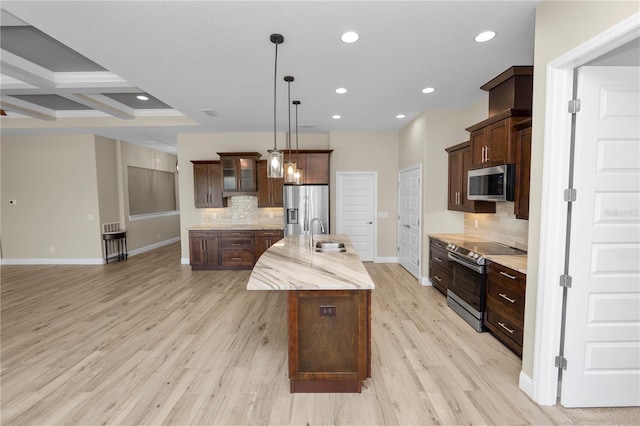 kitchen featuring a center island with sink, recessed lighting, light wood-style floors, appliances with stainless steel finishes, and baseboards