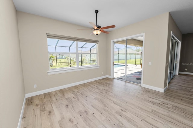 interior space with a ceiling fan, baseboards, and wood finished floors