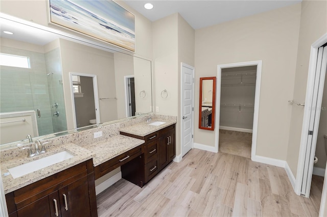 full bathroom featuring a stall shower, toilet, vanity, and baseboards