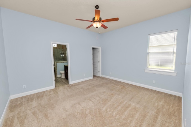 unfurnished bedroom featuring baseboards, ensuite bathroom, and carpet