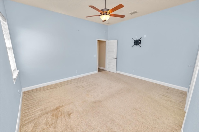 empty room with visible vents, baseboards, carpet flooring, and a ceiling fan