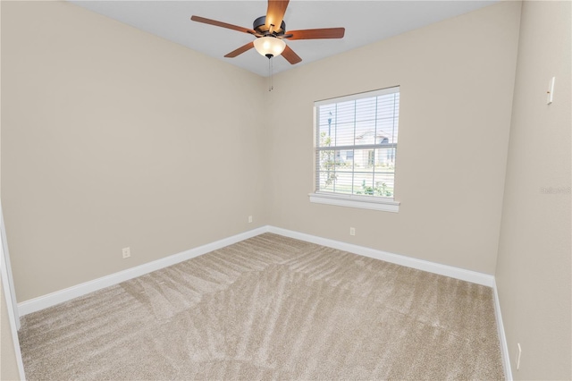 carpeted empty room with baseboards and ceiling fan