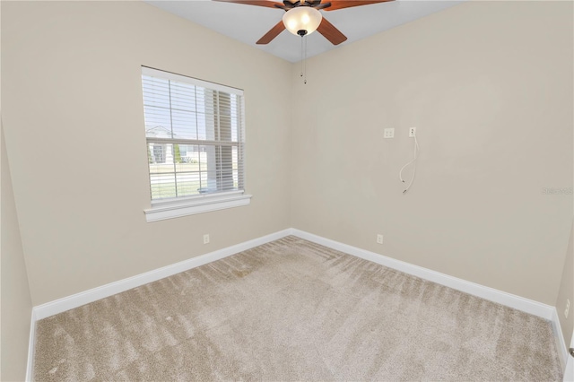 carpeted spare room featuring baseboards and ceiling fan