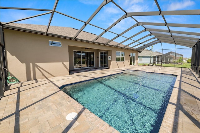 outdoor pool with glass enclosure, ceiling fan, and a patio area