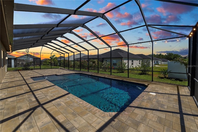 pool featuring glass enclosure and a patio