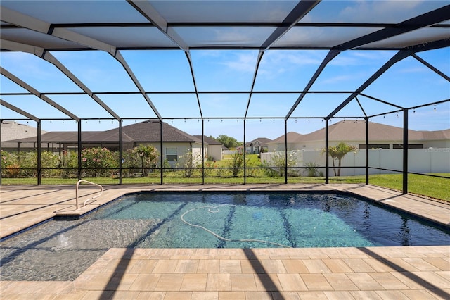 view of pool with glass enclosure, a patio, a fenced in pool, and a residential view