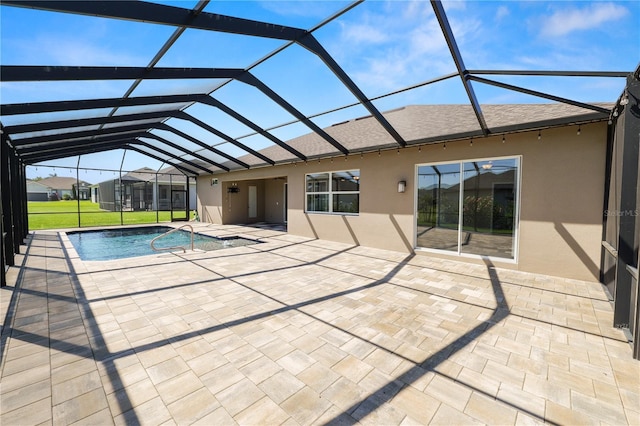 pool featuring a patio area, glass enclosure, and a yard