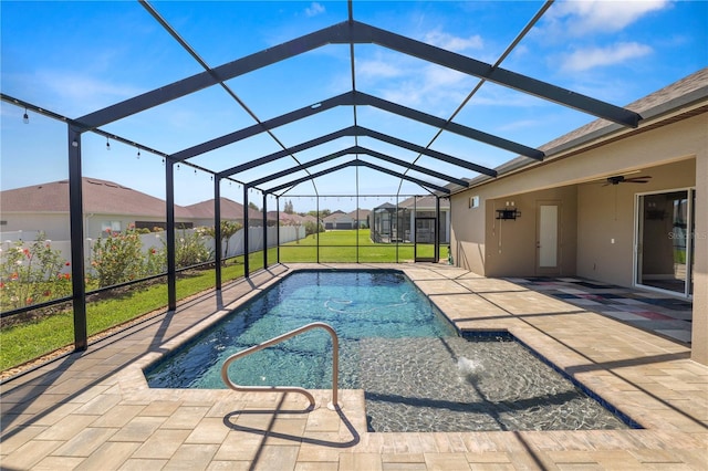 pool featuring a residential view, glass enclosure, a lawn, a patio area, and a ceiling fan