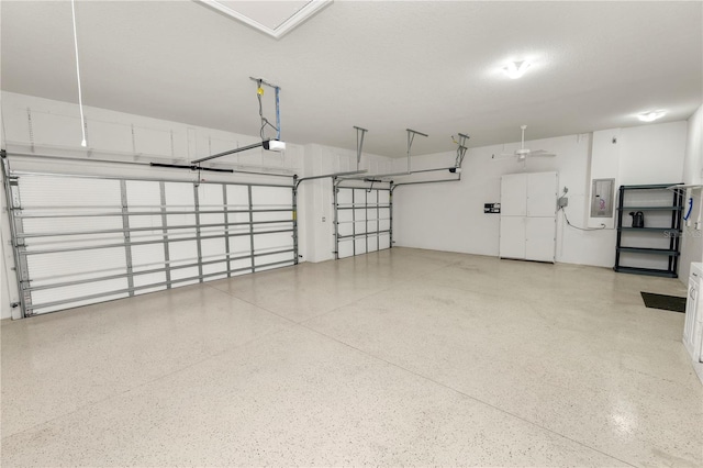 garage featuring electric panel, a garage door opener, and a ceiling fan