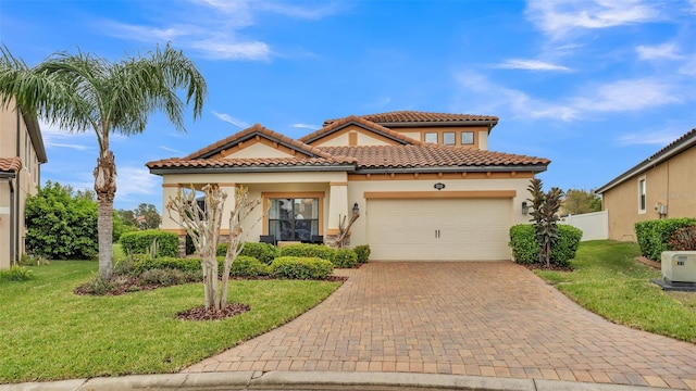 mediterranean / spanish-style house with decorative driveway, a front lawn, an attached garage, and stucco siding