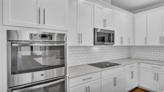 kitchen with white cabinetry, light stone counters, tasteful backsplash, and stainless steel appliances