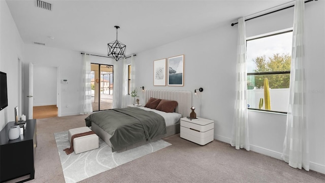 carpeted bedroom featuring visible vents, baseboards, and a chandelier