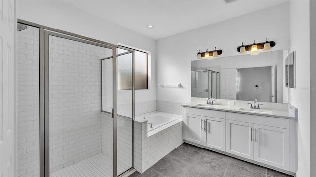 full bath featuring a garden tub, double vanity, a stall shower, tile patterned floors, and a sink